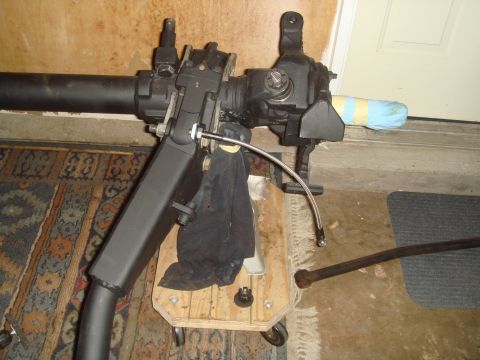 1992 Ford Bronco - A close-up view of a steering box and linkage assembly, likely for an off-road vehicle, resting on a wheeled wooden cart.