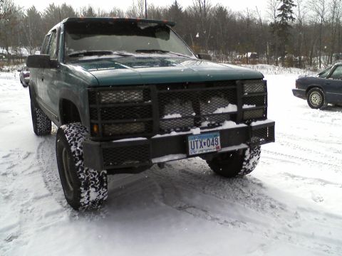 2000 Chevrolet Tahoe - Green pickup truck with aftermarket bumper and grille guard parked in the snow.