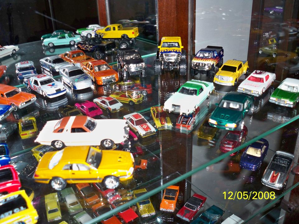 Toy cars on display shelves, including a yellow 1979 Ford Mustang model