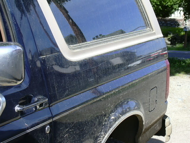 1991 Ford Bronco side view showing rear quarter panel, door handle, and chrome trim