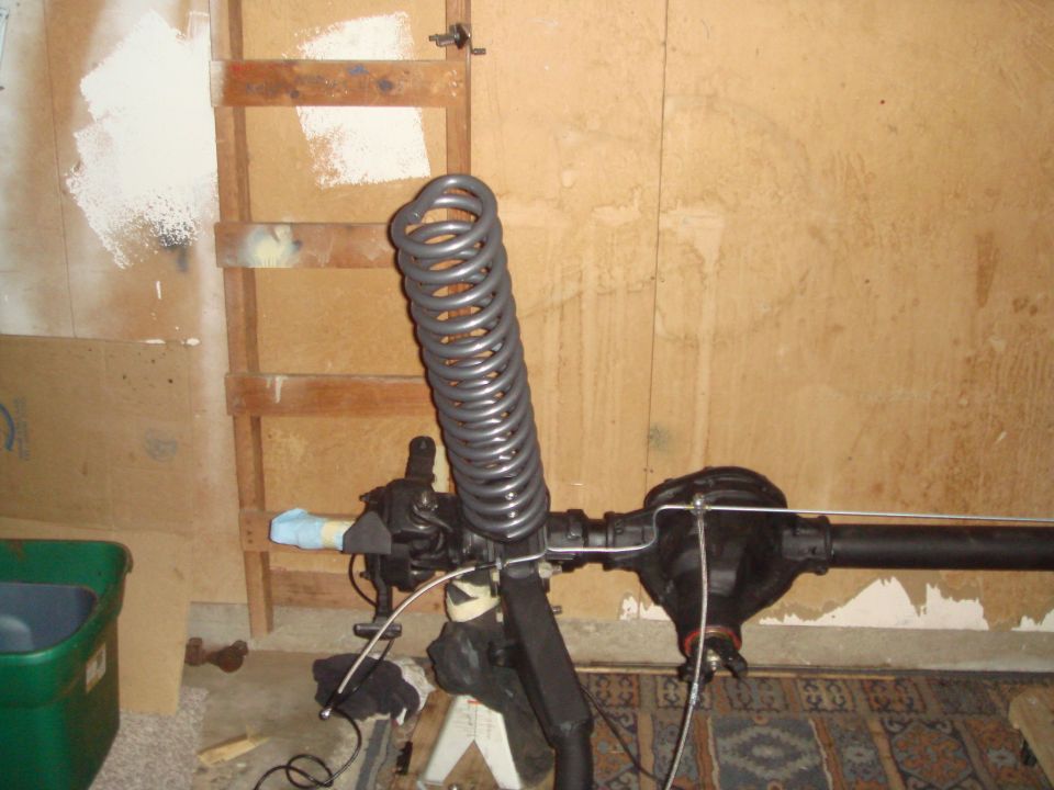 Front axle assembly with coil spring