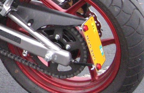 2008 Kawasaki Ninja R - The rear of a motorcycle is shown, a red-rimmed wheel, drive chain, and an Oregon license plate.