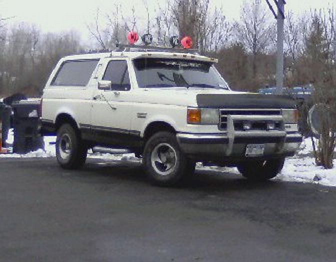 White 1991 Ford Bronco with aftermarket roof lights and bull bar