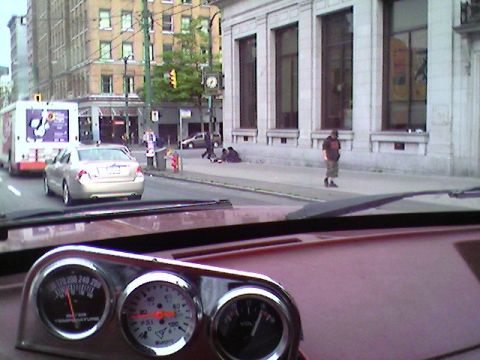 1989 Ford Bronco - Interior view of a vehicle's dashboard gauges with a city street scene in the background.