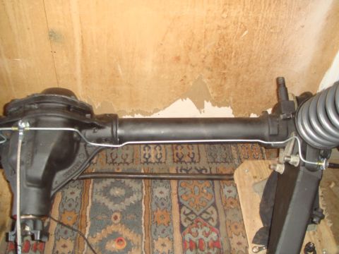 1992 Ford Bronco - Close-up of a differential axle assembly, likely a rear axle, with visible brake lines and a coil spring.