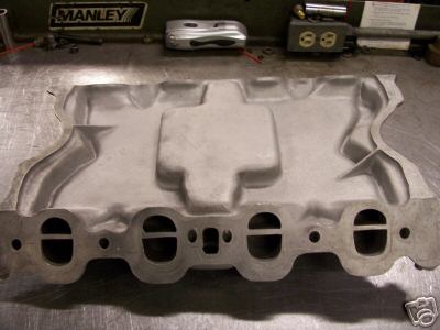 1972 Ford Ranchero - An aluminum intake manifold with dual ports is shown on a workbench, with "SUPERMOTORS.NET" visible at the bottom.