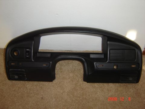 1993 Ford Bronco - This is a dashboard bezel, likely from an older vehicle, shown against a plain wall and carpeted floor.
