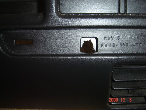 1993 Ford Bronco - Close-up of a damaged black plastic dash bezel showing part numbers and a hole.