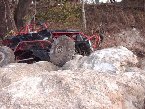 1982 Ford F-100 - Custom off-road buggy with large tires climbing over rocks.