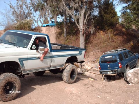 1982 Ford F-100 - A Ford pickup truck is assisting a blue SUV that is stuck in a rocky area.