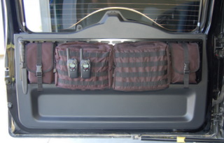 1984 Ford Bronco - Storage pouches and radios are mounted inside the rear door of an SUV.