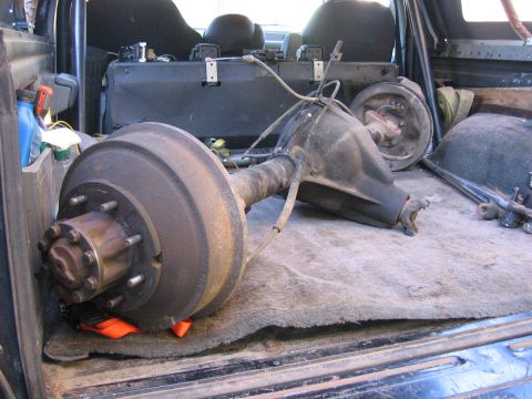 1989 Ford Bronco - A disassembled rear axle assembly is stored in the cargo area of a vehicle.