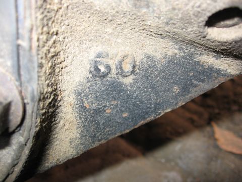 1989 Ford Bronco - A close-up view of a metal component stamped with the number 60, covered in dust.