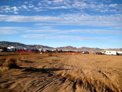 1996 Ford Bronco - A desert campsite with multiple RVs and vehicles under a blue sky with clouds.