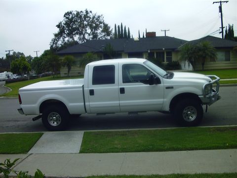 2001 Ford F-250 - This 2001 Ford F-250 pickup truck is seen from the side, parked on a suburban street.