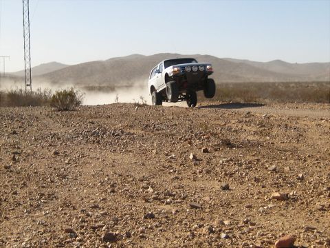 1996 Ford Bronco - This modified SUV is airborne on a dusty desert road.