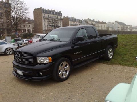1991 Ford Crown Victoria - A black Dodge Ram 1500 pickup truck is parked outdoors with buildings in the background.