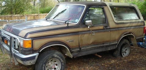 1988 Ford Bronco - This Ford Bronco appears to be from the late 1980s, possibly a 1987 model, with a flat tire and some rust.