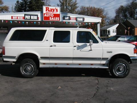 1991 Ford C-350 (Centurion Conversions) - White 1991 Ford C-350 Centurion Conversions extended cab pickup truck parked in front of a car dealership.
