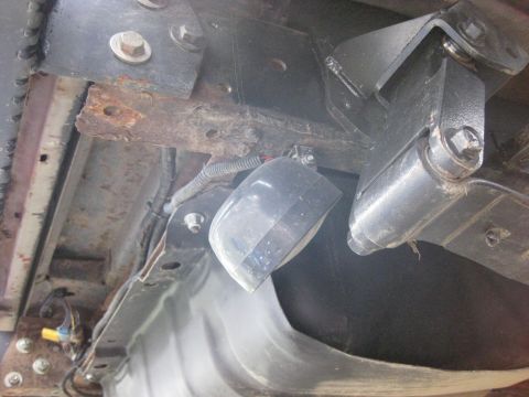 1979 Ford Bronco - Close-up of aftermarket rock lights mounted to the undercarriage of a vehicle, showing frame and suspension parts.