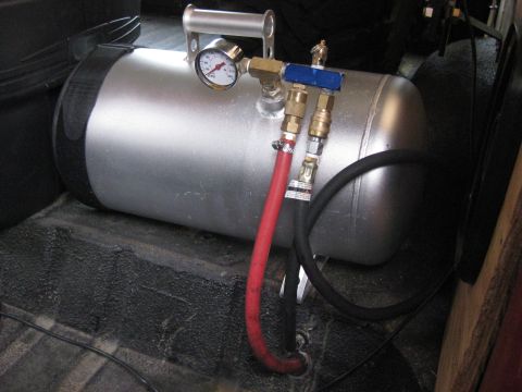 1979 Ford Bronco - Close-up of an air compressor tank, a pressure gauge and connected hoses, likely installed in a vehicle's cargo area.