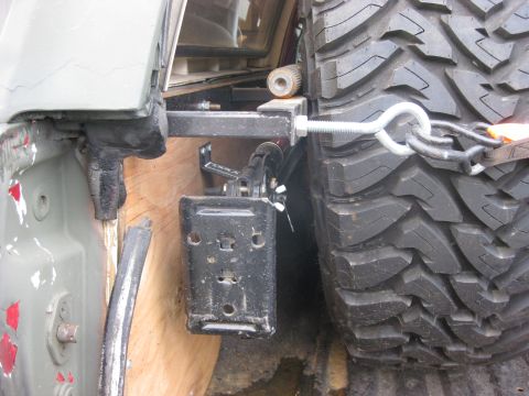 1979 Ford Bronco - Detail of a spare tire mount mechanism and a large off-road tire.
