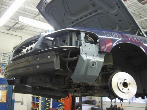 2001 Ford Crown Victoria - The front end of a 2001 Ford Crown Victoria is shown with its hood and bumper removed for repairs.