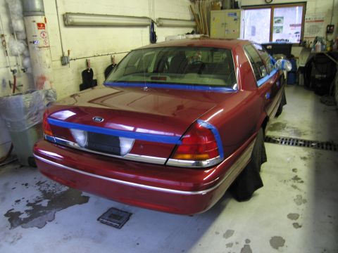 2001 Ford Crown Victoria - This 2001 Ford Crown Victoria is taped up for paint repair in a garage setting.