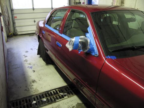 2001 Ford Crown Victoria - Red 2001 Ford Crown Victoria with driver's side door and mirror taped off for painting.