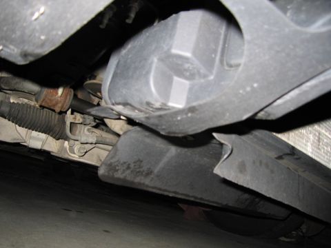2001 Ford Crown Victoria - A low-angle view of a vehicle's undercarriage reveals suspension parts and protective shielding.