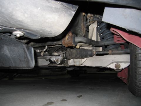 2001 Ford Crown Victoria - A close-up view of the steering rack and suspension system on the underside of a vehicle.