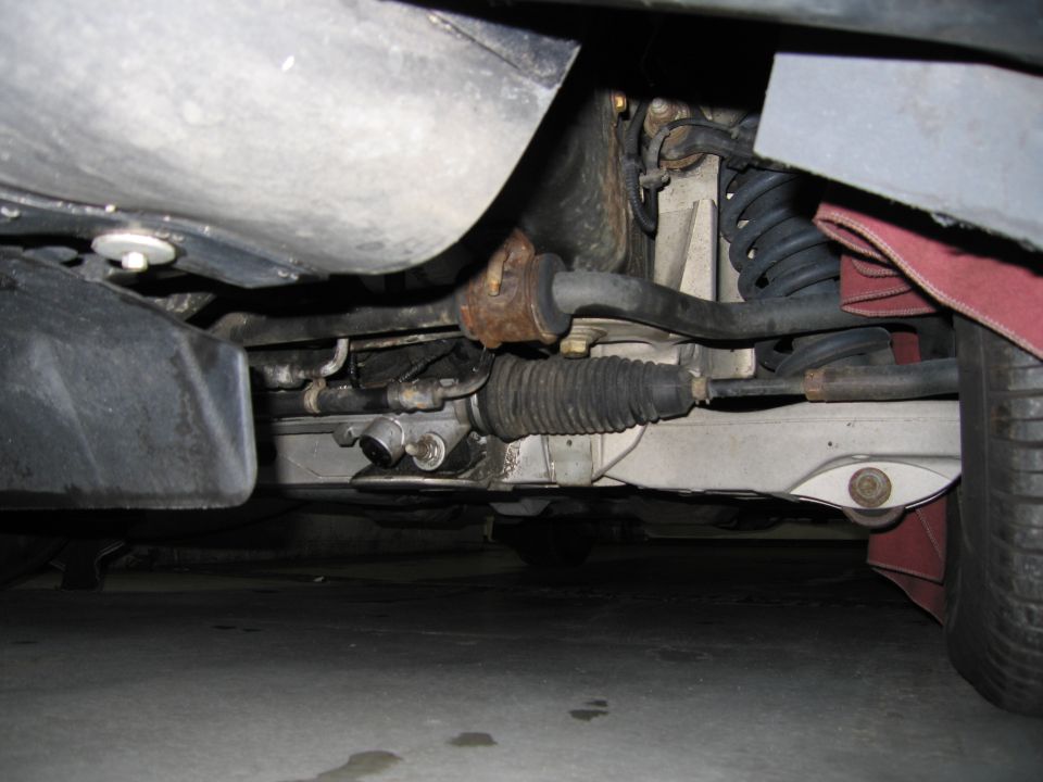 Undercarriage view of vehicle steering rack and suspension components