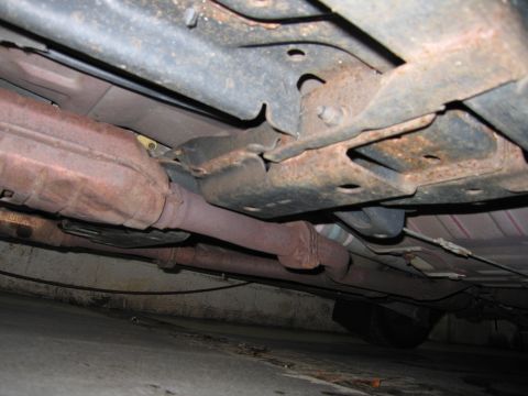 2001 Ford Crown Victoria - Undercarriage view showing exhaust system and frame components, with visible rust.
