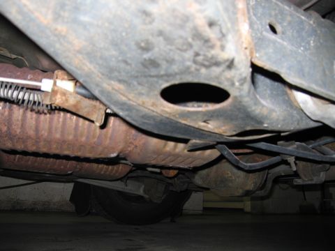 2001 Ford Crown Victoria - The underside of a vehicle is visible, with significant rust on the exhaust system and frame components.