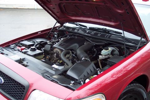 2001 Ford Crown Victoria - The engine bay of a red 2001 Ford Crown Victoria is shown with the hood open.
