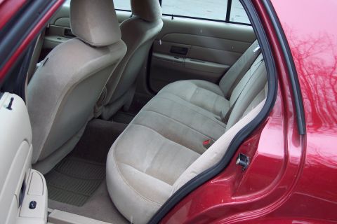 2001 Ford Crown Victoria - Rear interior of a 2001 Ford Crown Victoria, showing tan cloth seats and door paneling.