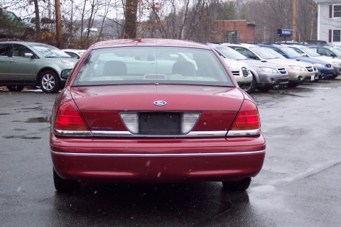 2001 Ford Crown Victoria - Rear view of a red 2001 Ford Crown Victoria parked outdoors on a wet day.