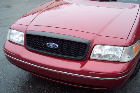 2001 Ford Crown Victoria - Front view of a red 2001 Ford Crown Victoria showing the grille and headlights.