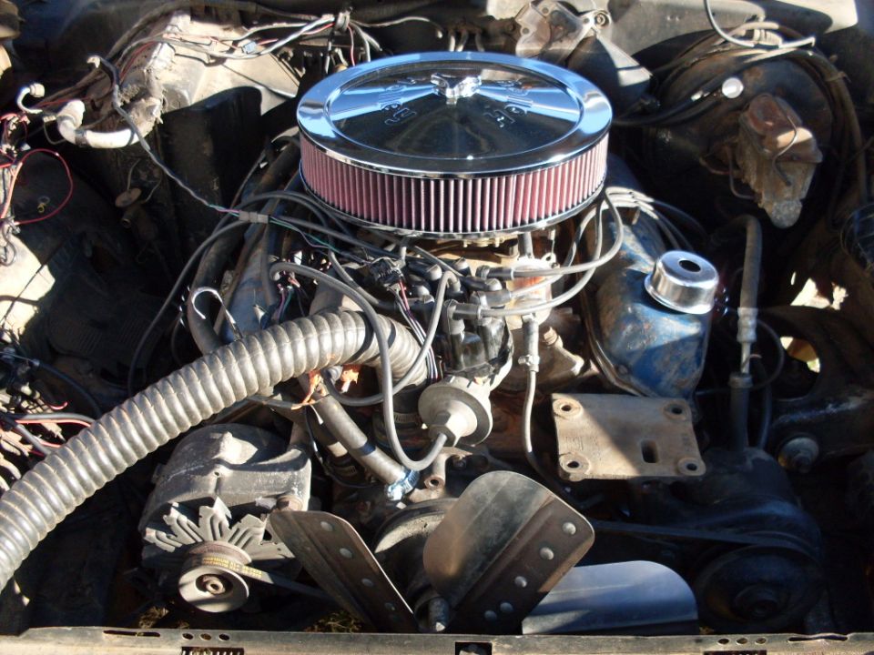 V8 engine with chrome round air cleaner and red filter in engine bay