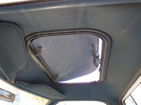 1972 Ford Ranchero - The interior of a vehicle shows a sunroof with visible latches and a blue sun visor.