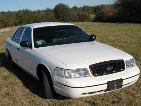 2000 Ford Crown Victoria - A white 2000 Ford Crown Victoria is shown from a 3/4 front angle, parked outdoors on a grassy field.