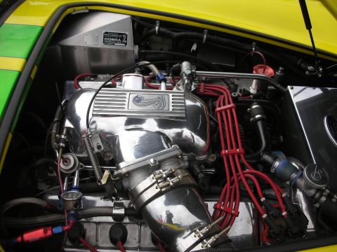 1998 Ford Crown Victoria - The engine bay features a prominent chrome intake manifold with Cobra branding and bright red spark plug wires.