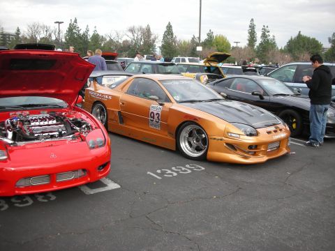1998 Ford Crown Victoria - Two Mitsubishi 3000GT VR-4s are parked side-by-side at an outdoor car meet.