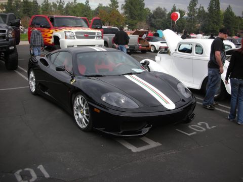 1998 Ford Crown Victoria - A black Ferrari 360 Modena is parked at an outdoor car show with other vehicles.