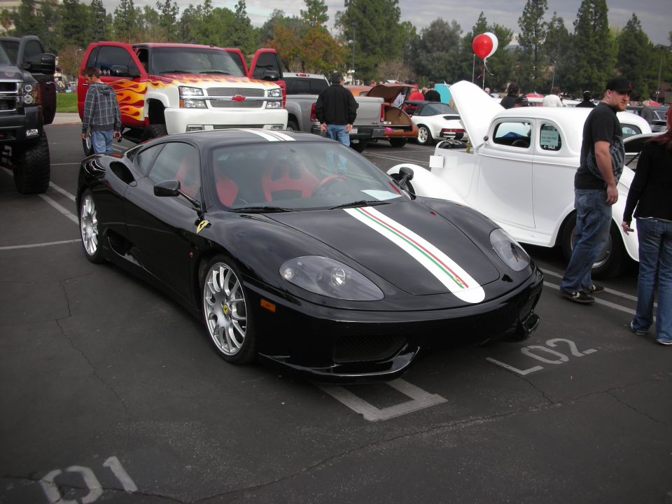 Black Ferrari 360 Modena with red interior and racing stripes on hood