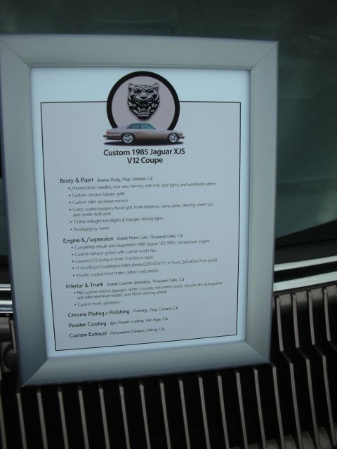 1998 Ford Crown Victoria - Printed build-spec display card listing body, engine, suspension and interior details of a custom 1985 Jaguar XJS.