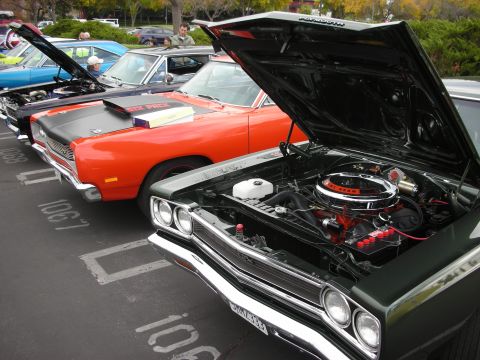 1998 Ford Crown Victoria - A lineup of vintage cars with their hoods open, their engines in a parking lot setting.