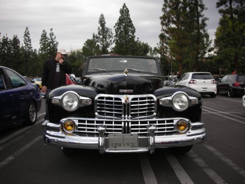 1998 Ford Crown Victoria - A classic black Lincoln Continental convertible is parked facing forward, with other vehicles visible in the background.