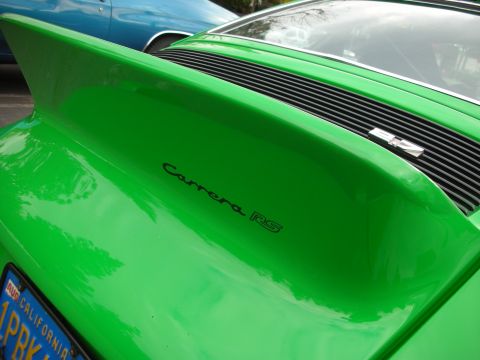 1998 Ford Crown Victoria - A bright green Porsche Carrera RS is seen from the rear, with a blue car in the background.