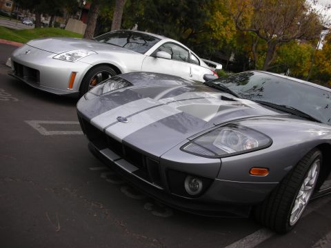 1998 Ford Crown Victoria - Two sports cars, a Ford GT and a Nissan 350Z, are parked in a lot.